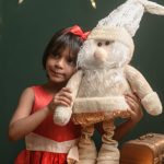 Little girl with Santa toy in Christmas photoshoot